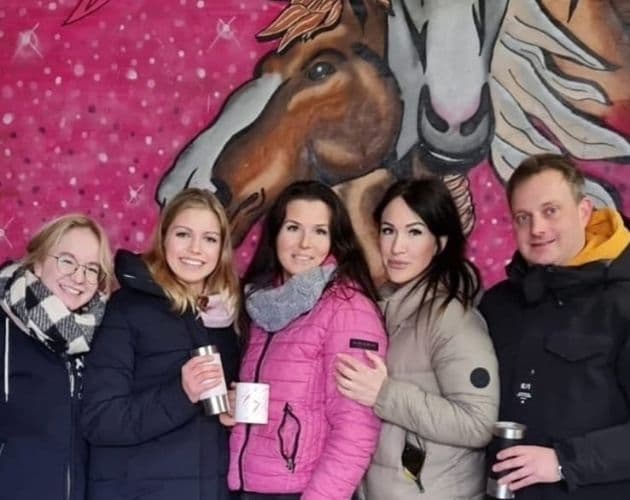 Gemeinschaft vor dem Pferde-Wandbild