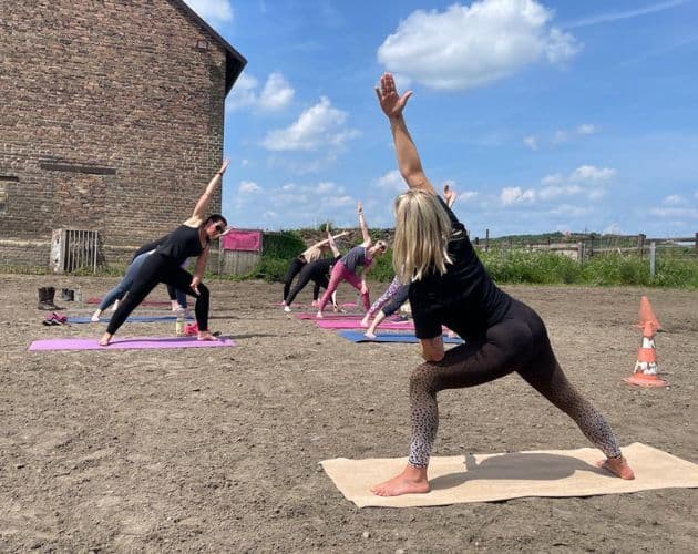 Yoga-Stunde vor dem Hof